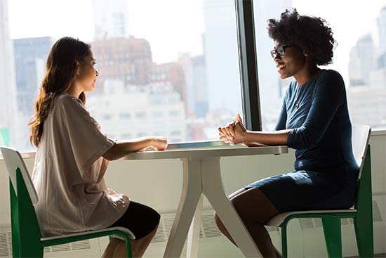 Two women sitting at a table having a job intervju